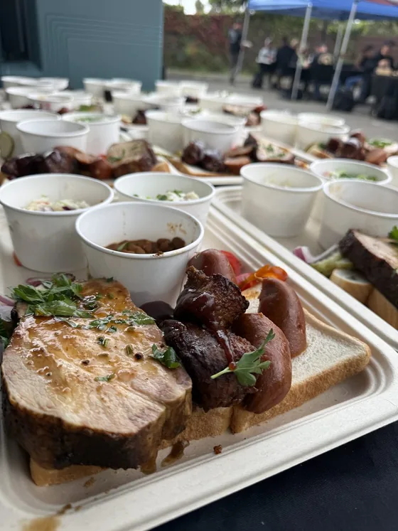 Catered BBQ trays with sausage, brisket, beans and slaw